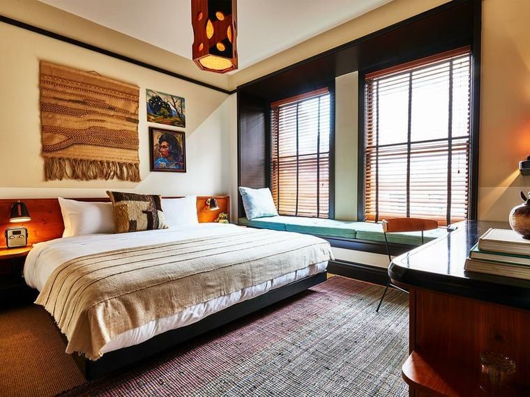 Deluxe Room with dual-aspect windows and a reading chair